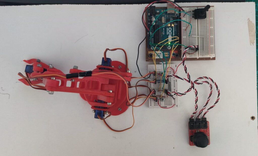 Vista del brazo robótico con Arduino y servomotores montado sobre una madera